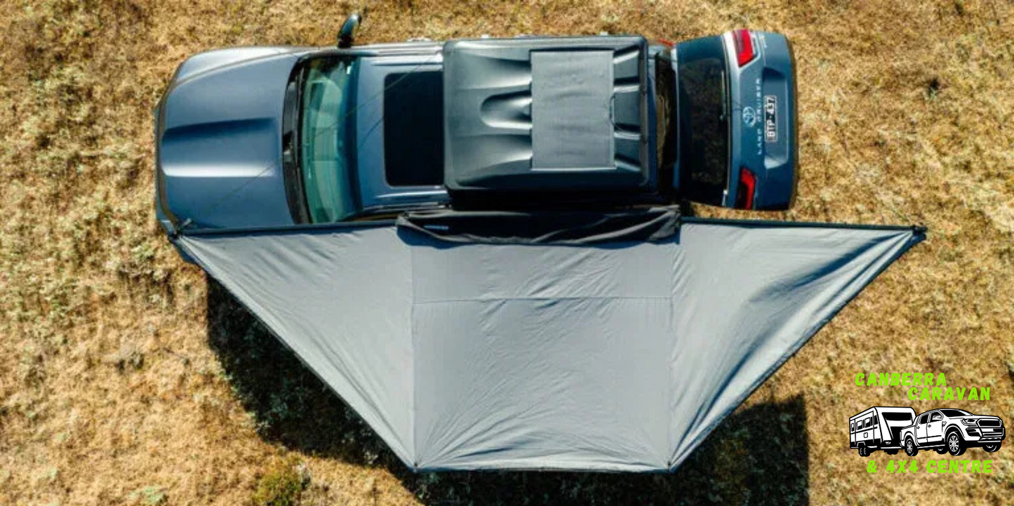 Car with a gray tent set up on a grassy field, with a logo in the corner.