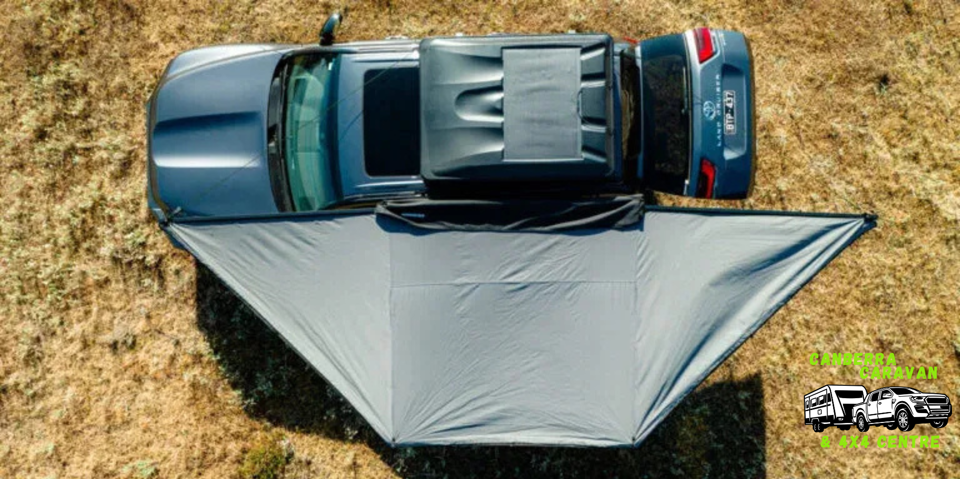 Car with a gray tent set up on a grassy field, with a logo in the corner.